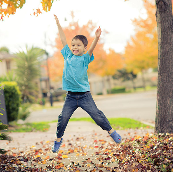 Child jumping in leaves