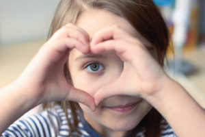 Child making heart with hands