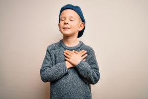 Child with hands over their heart