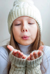 Child blowing snowflakes